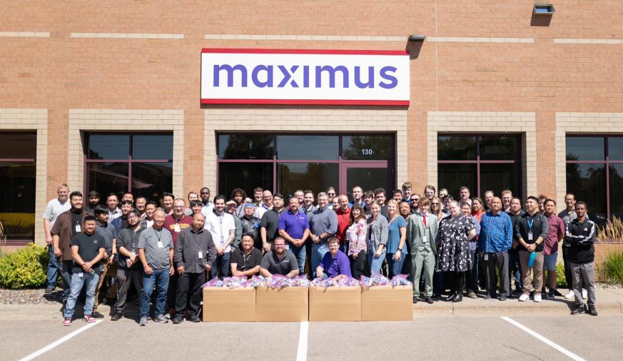 Corporate IT office in Eagan, MN gives back to The Open Door A large group posed outside a Maximus building, packed boxes in front of them.