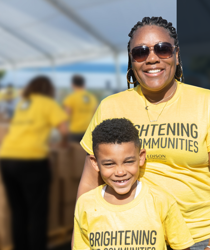 An adult and child smiling in matching tshirts.