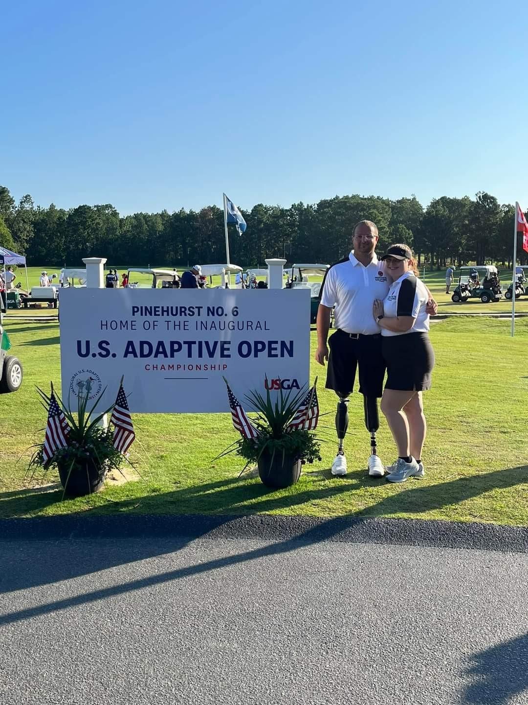 golfers posing next to sign