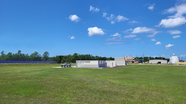 Exterior of energy facility. Blue sky and green lawn surrounding.