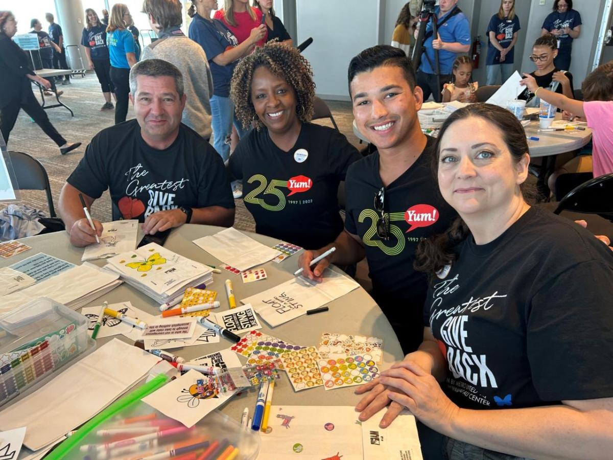 4 volunteers make crafts at a table