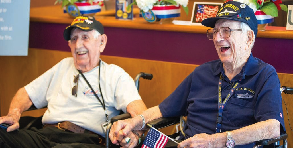 Ninety-two-year-old Stan Hergott (left) and 94-year-old Ken Brock share a laugh telling stories as they visited Hallmark with fellow veterans from the USS Hornet.