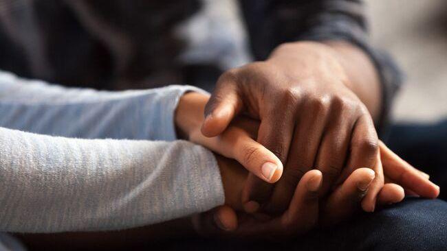 close up of two people holding hands