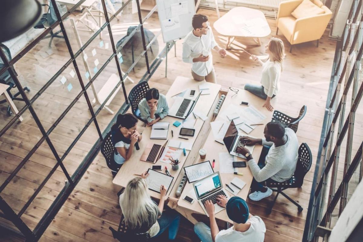 (Image: Vasyl/Adobe Stock) Aerial view of people working at a desk together