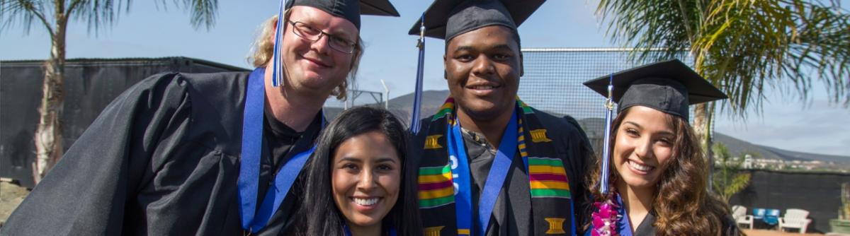 4 students in graduation caps and gowns