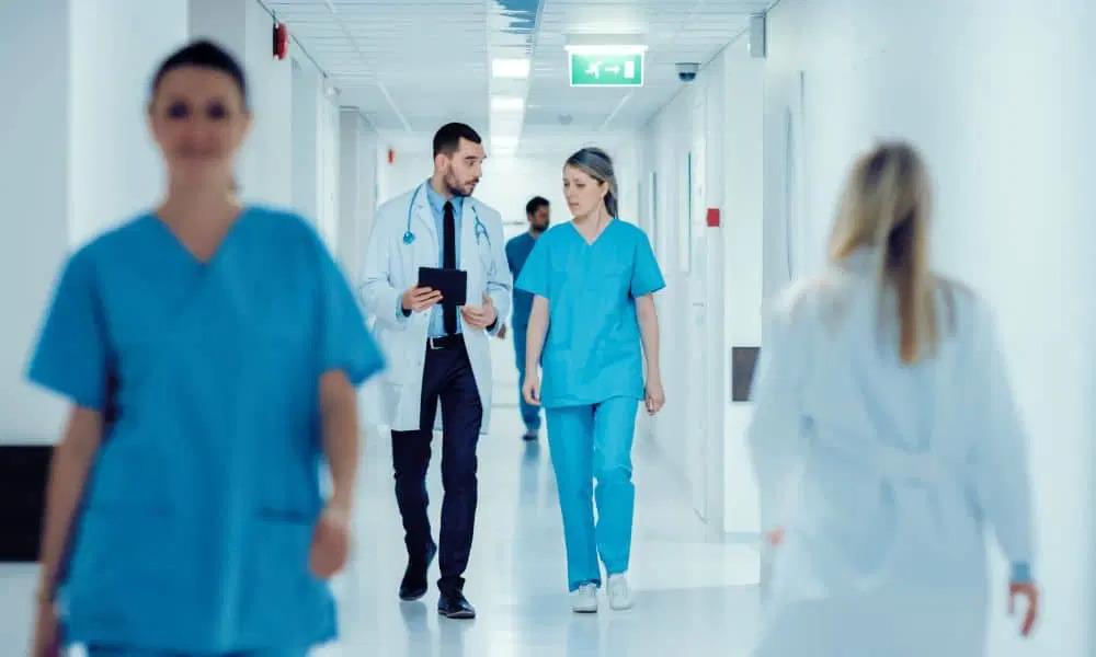 Image courtesy of Healthcare Business Today Medical professionals walking down a hallway. Two talking together.