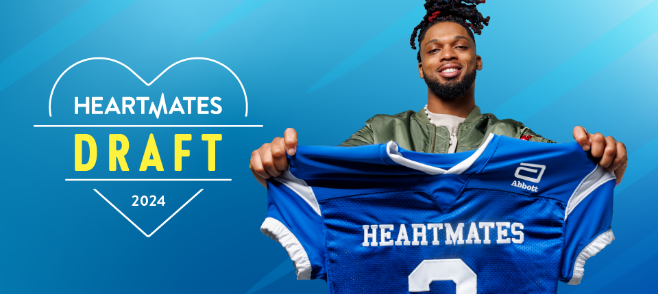 Damar Hamlin holding a blue "Heartmates" football jersey.