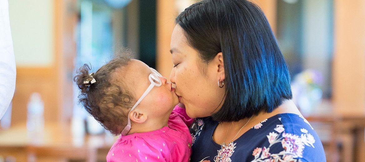 Person holding a child wearing glasses