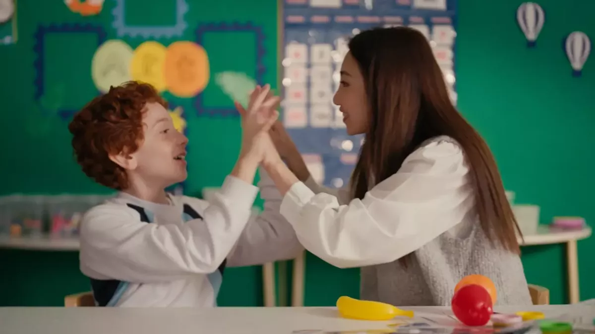 A child and a teacher high-fiving 