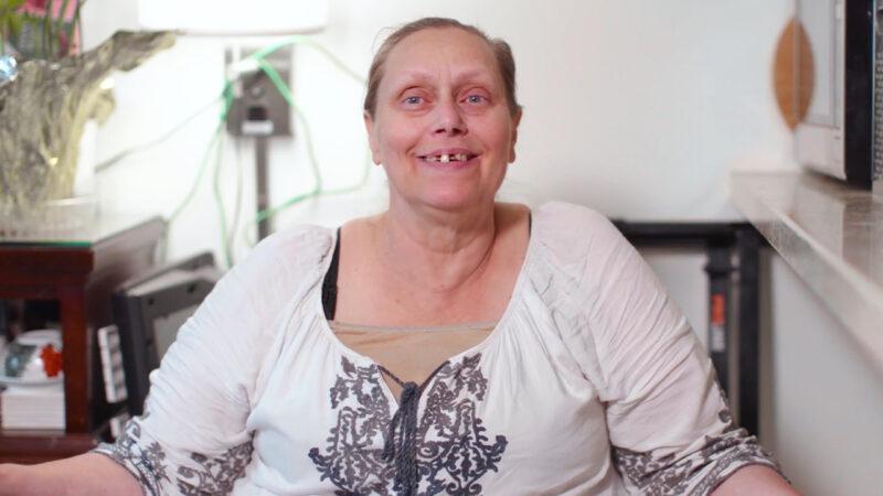 After losing housing and then living in temporary housing, Karrie found her home in Hollywood because of California’s Project Homekey program. close up of a woman sitting in her home