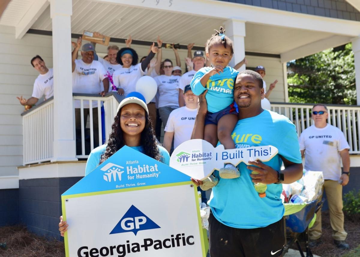 team standing in front of house