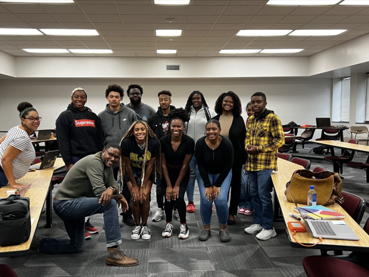 Students all standing in a group smiling at the camera 