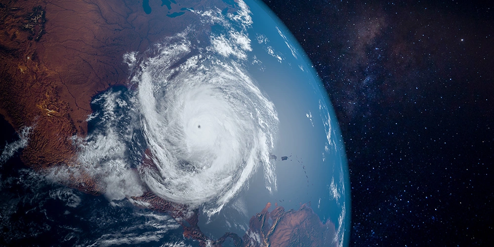 View from outer space towards the Earth. A large hurricane is central.
