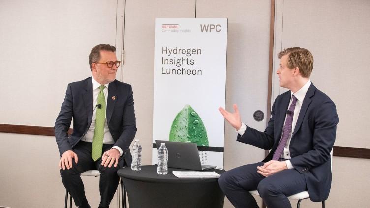 Photo Credit: S&P Global and WPC 2023 Two people sitting at a table with poster "Hydrogen Insights Luncheon" behind them