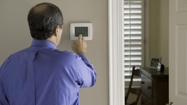 Someone adjusting a thermostat