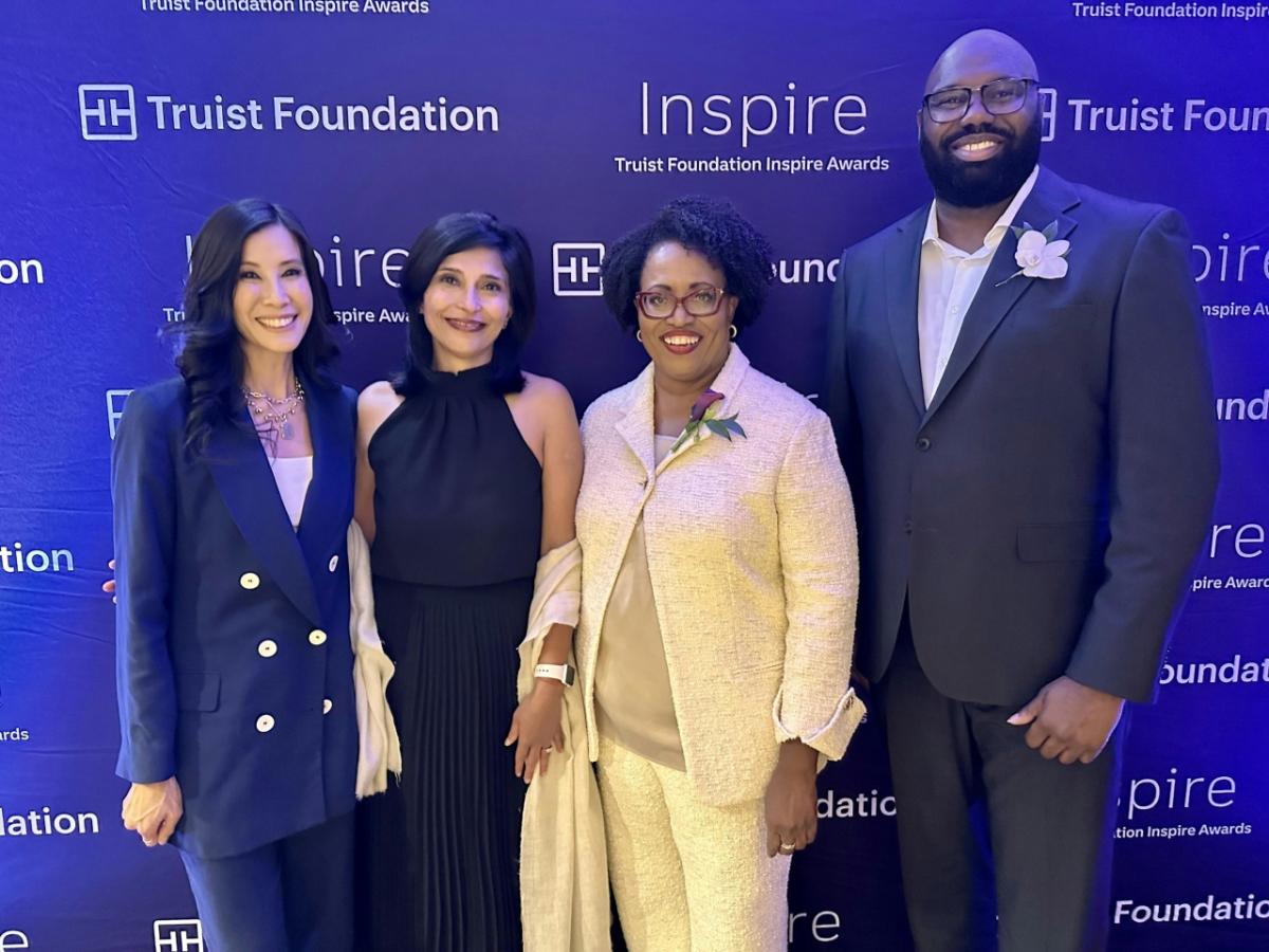 Four people standing in front of a blue screen with Truist foundation and Inspire logos.