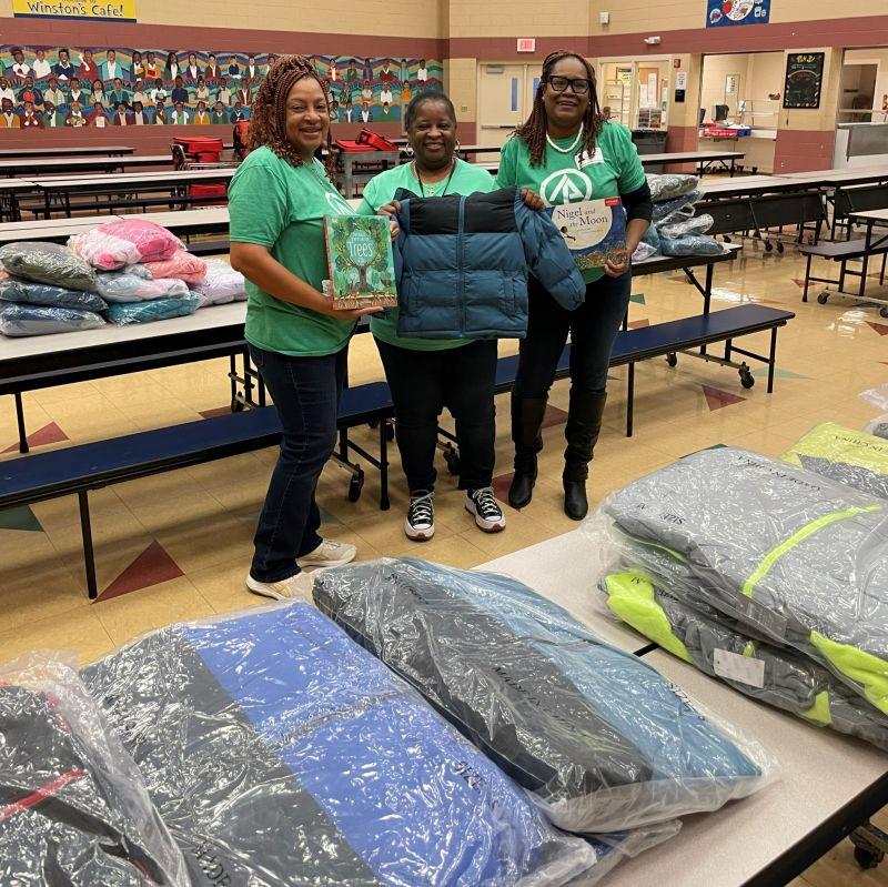 International Paper volunteers smiling with a child's coat 