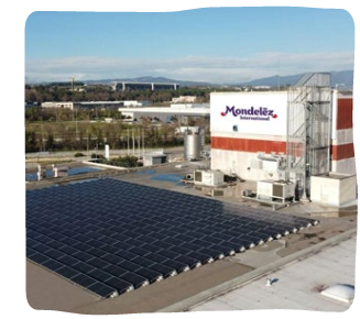Aerial view of a block of solar panels beside a Mondelez factory.