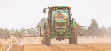 A tractor spraying a bare field