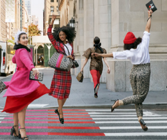 Four people dancing on a city street, each wearing a unique kate spade outfit.