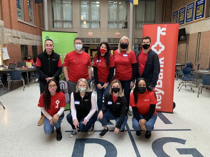 Nine KeyBank volunteers pose for a group photo. All are wearing red KeyBank t-shirts and masks.