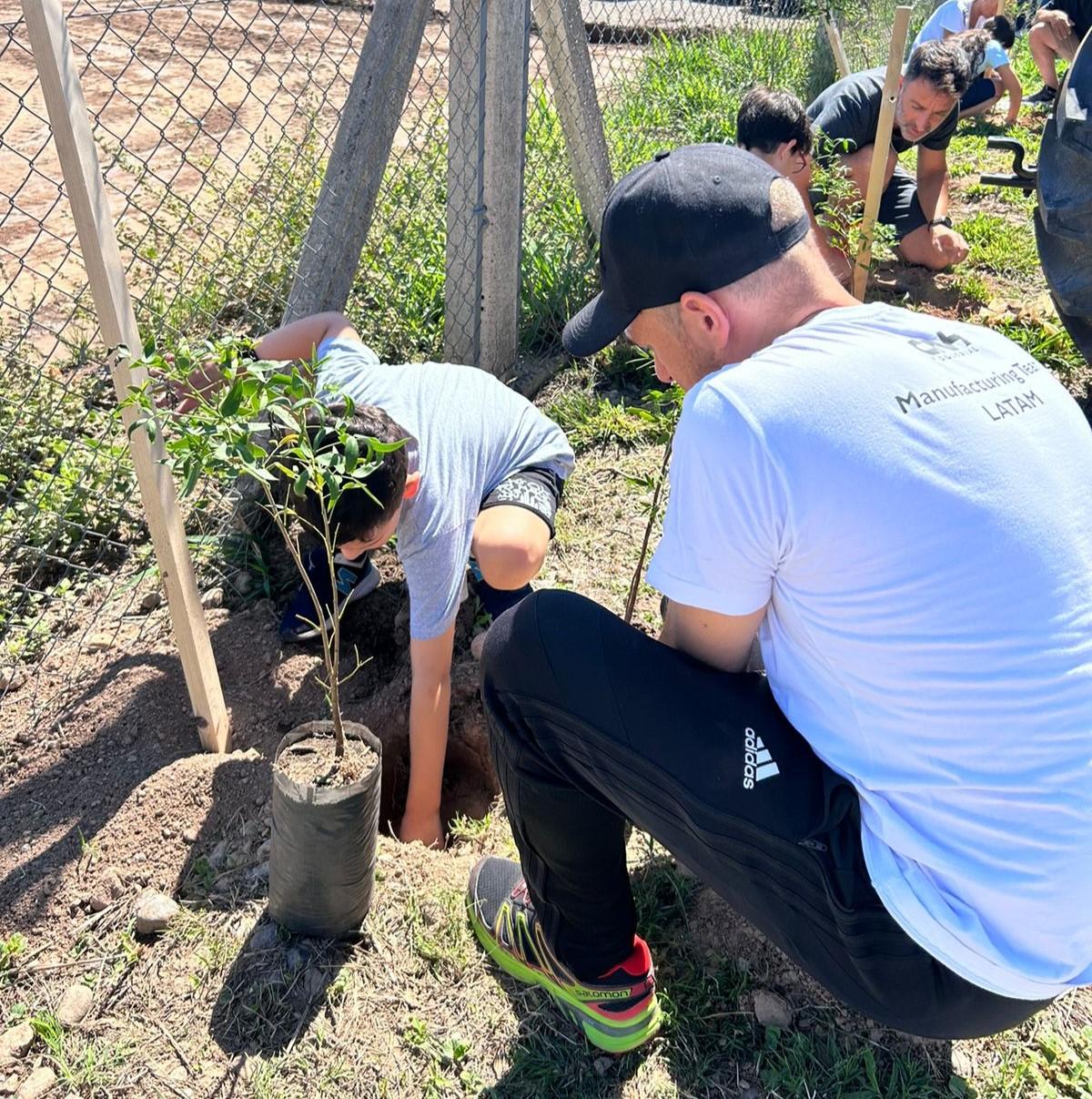 An adult and child planting a tree.