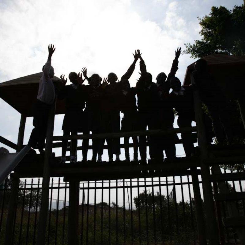 A silhouette of a group of people with their hands raised.