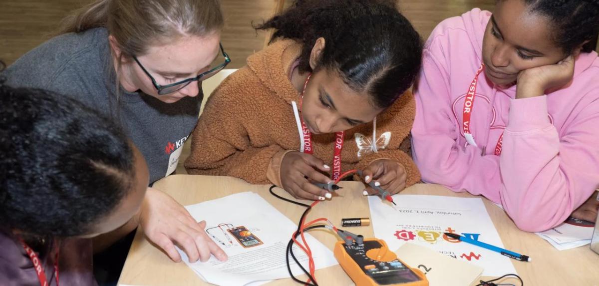 Kids working together with written instructions and electronics, wires and batteries.