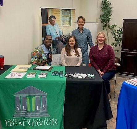 Five people posed behind a display table.