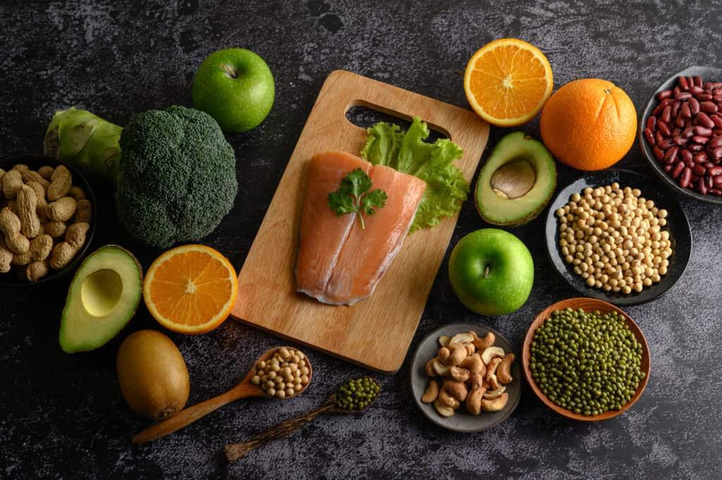 Legumes, vegetables and fruits shown on a cutting board.
