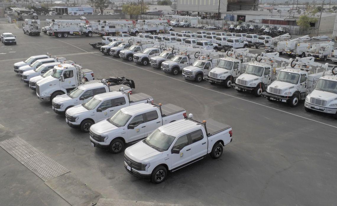 Aerial view of a parking lot full of identical trucks and service vehicles.