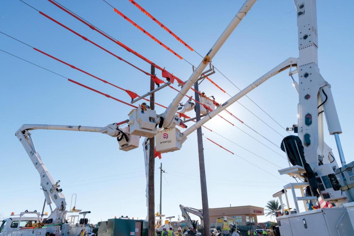 A person in a raised bucket working on a power line.