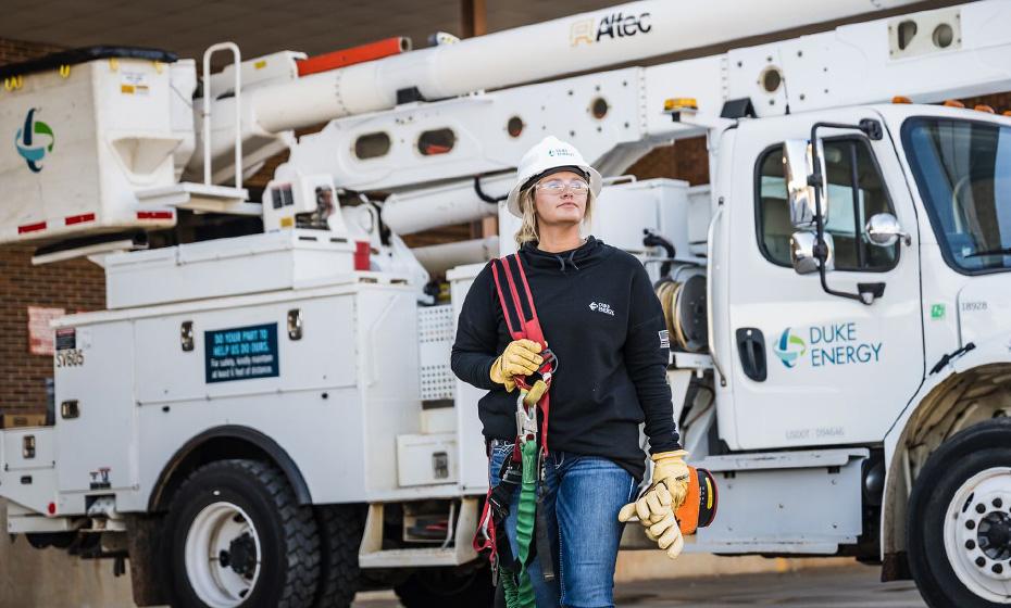 A line-worker walking away from a bucket truck.