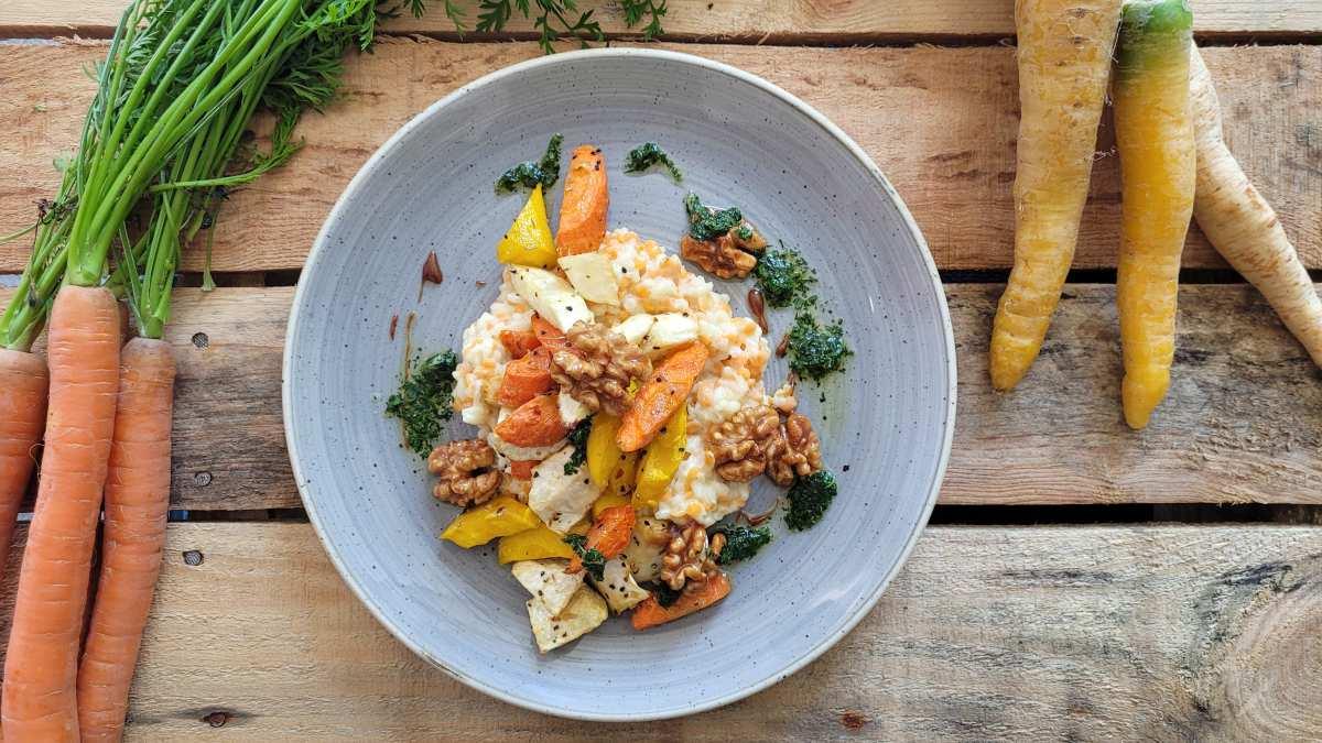 Plate of lentil risotto surrounded by bunches of carrots