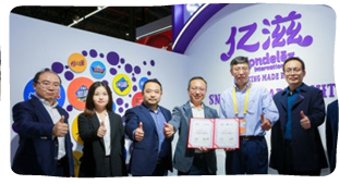 A group of six people posed, giving thumbs-up. Two hold awards.