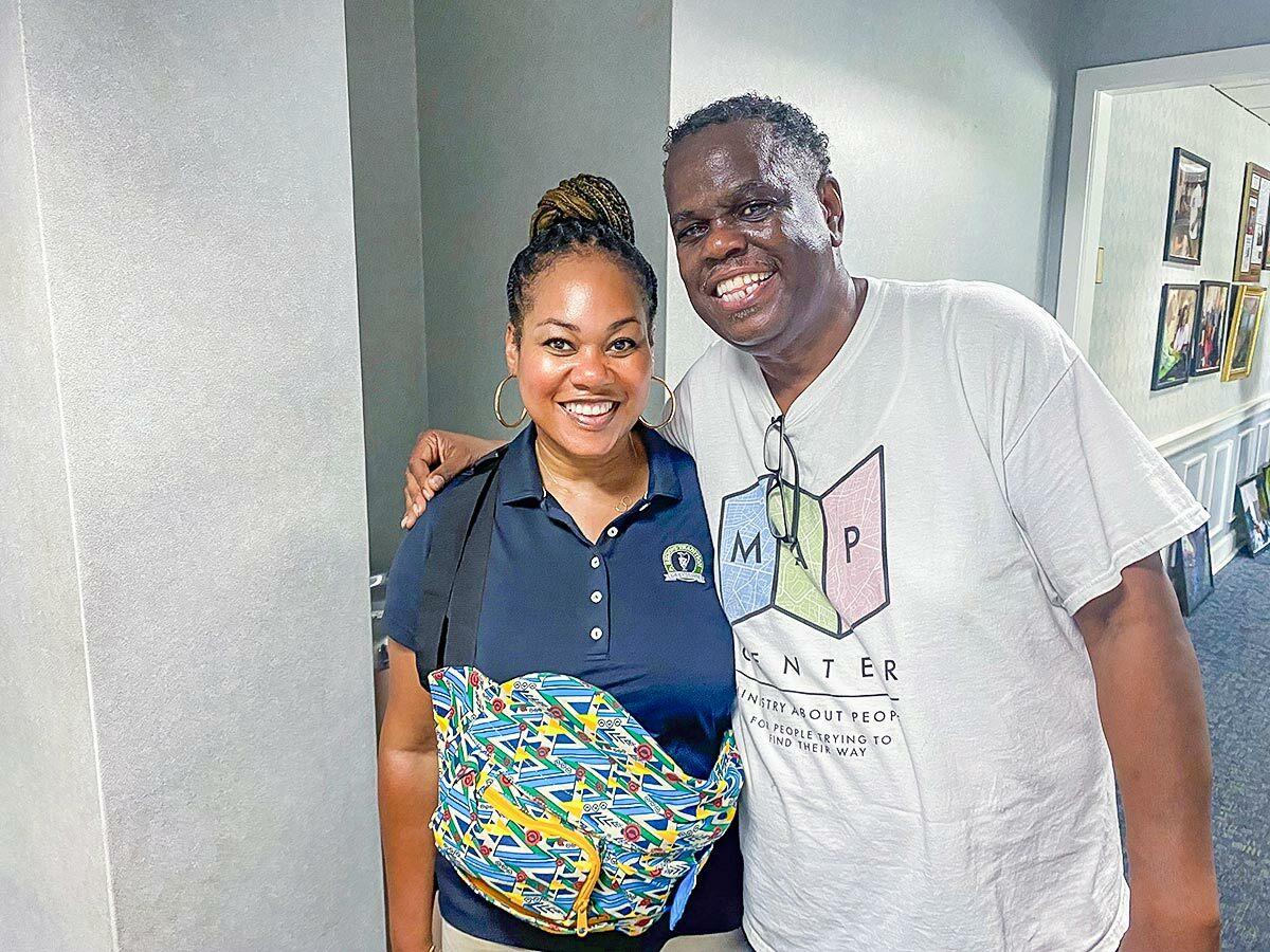 two people in a hall way, one wearing a "MAP center" tshirt