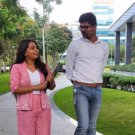 Yash and her supervisor walking outside on a walkway.