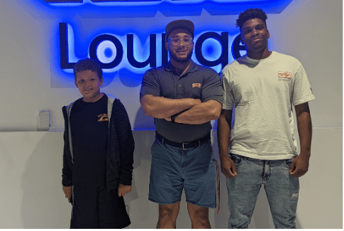 3 people standing in front of a "lounge" sign