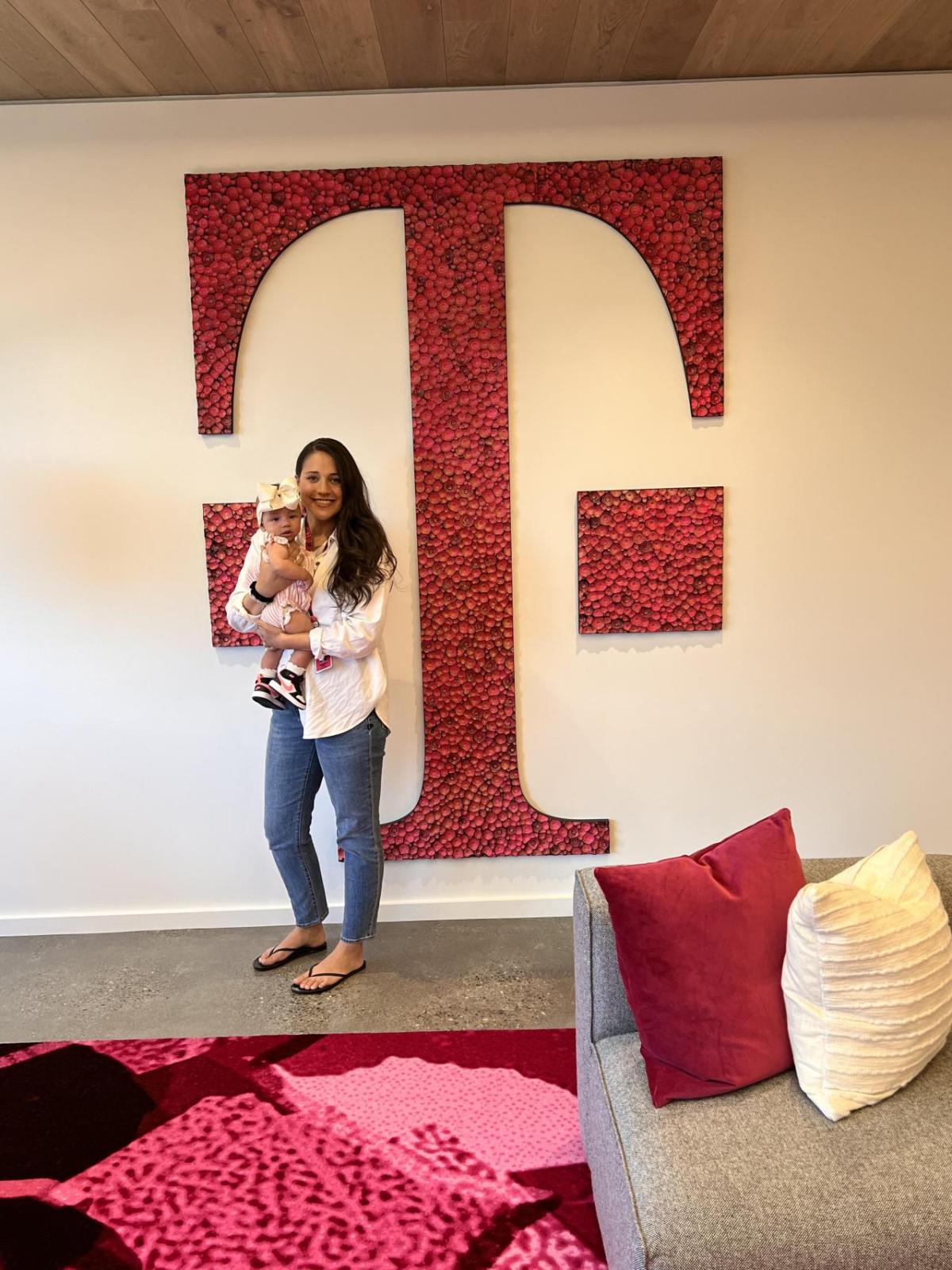  Logan Mcintosh and Brooke in front of a large T on a wall.