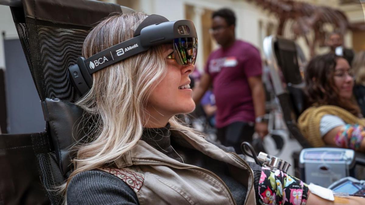 Person seated wearing Abbott mixed reality device 