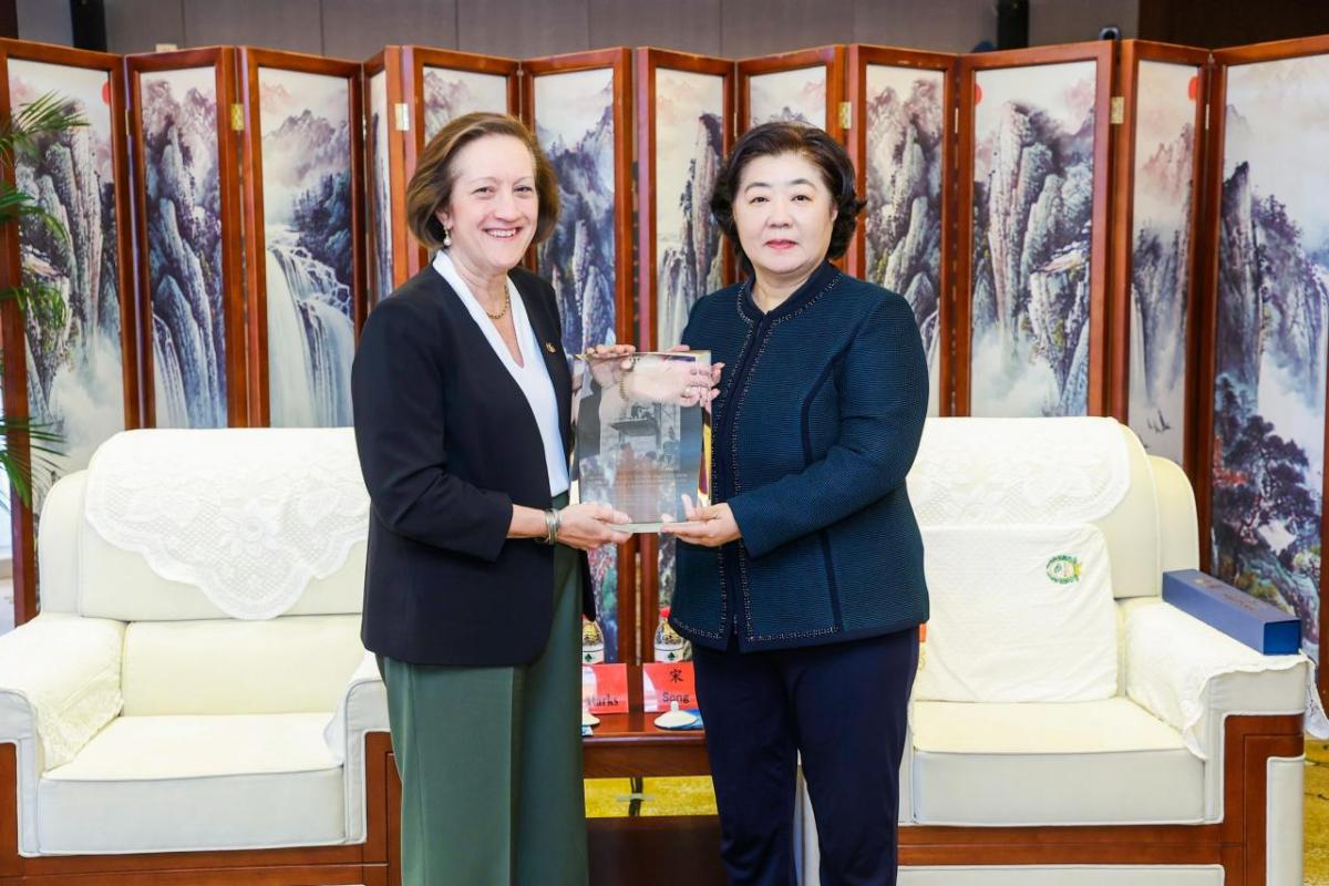 two women holding plaque 