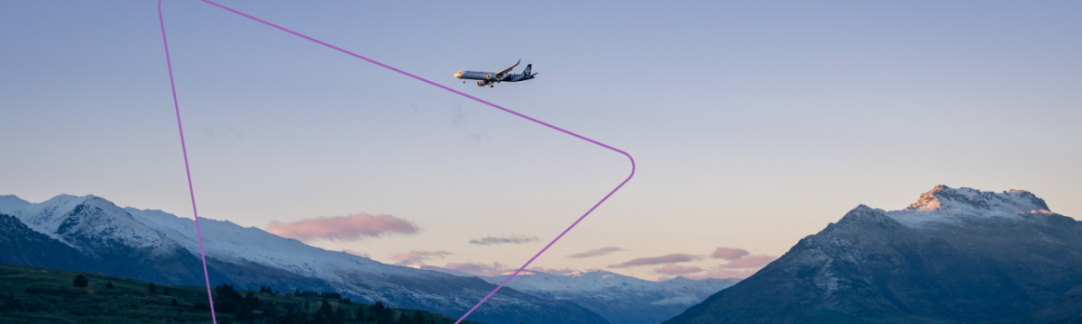 A plane in flight over mountain terrain.