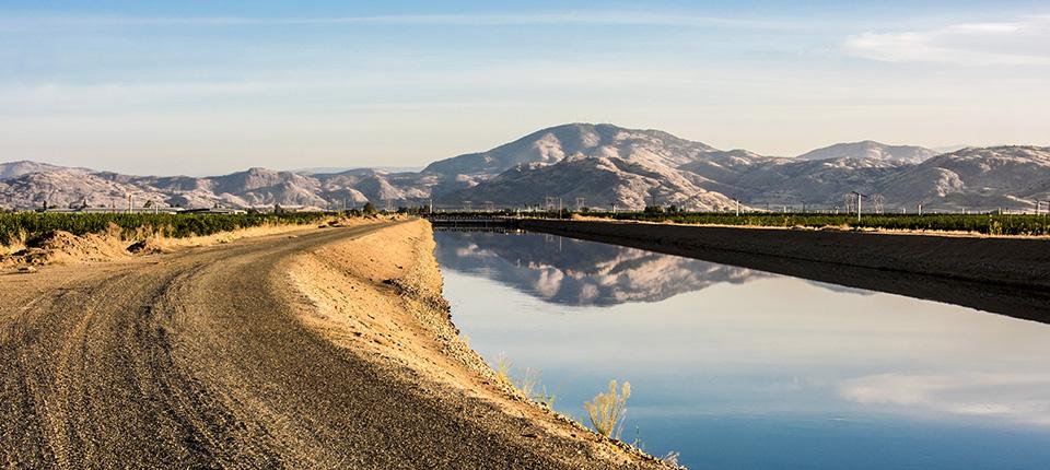 A dirt road with mountains in the background