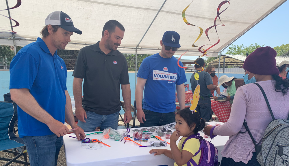 a group of marathon volunteers at a table, a child and adult on the other side