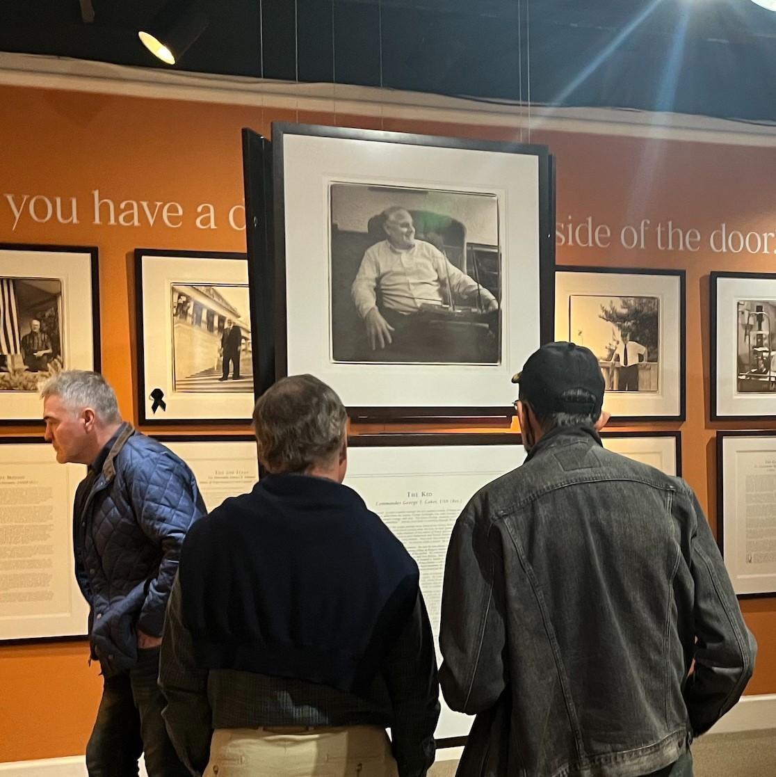 People looking at a photograph in a museum.