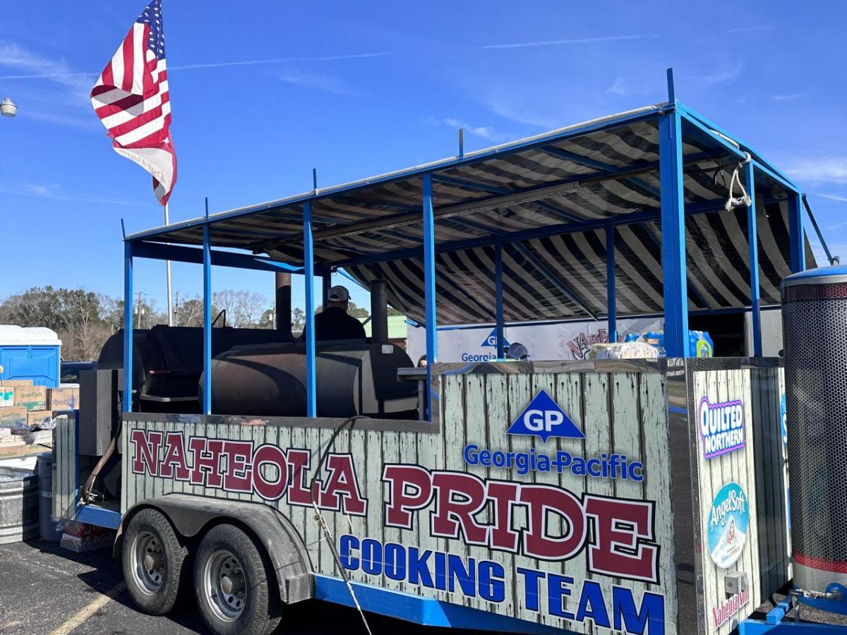 Cooking trailer with open sides and "Naheola Pride cooking team" on the side with Georgia-Pacific logo