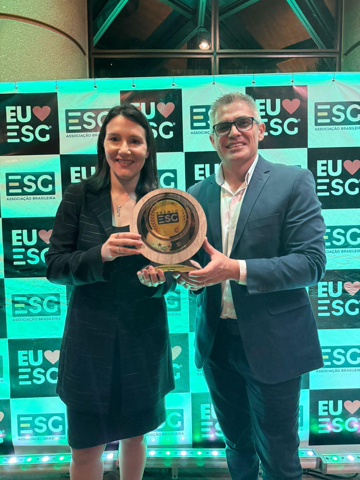 two people holding award at event
