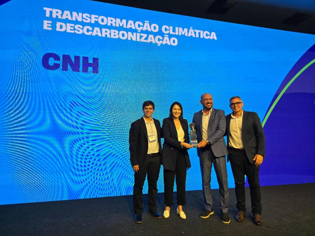 four people holding an award on a stage