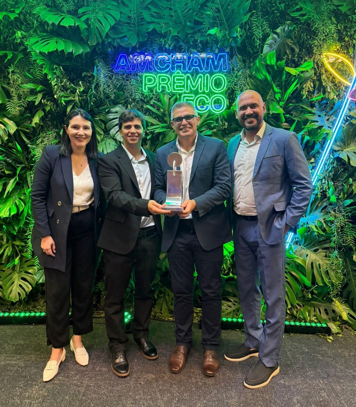four people holding an award