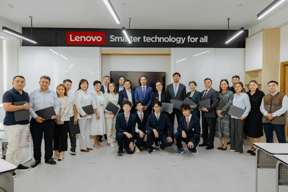 A group under a sign that reads: "Lenovo - Smarter technology for all"